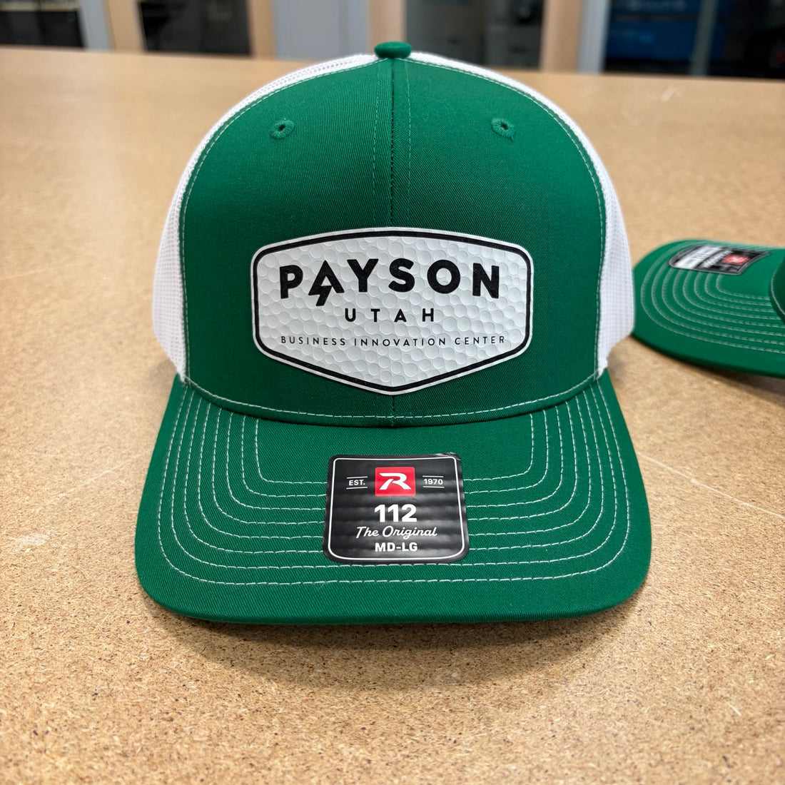 Green tournament hat with a golf ball textured Payson Business Innovation Center patch