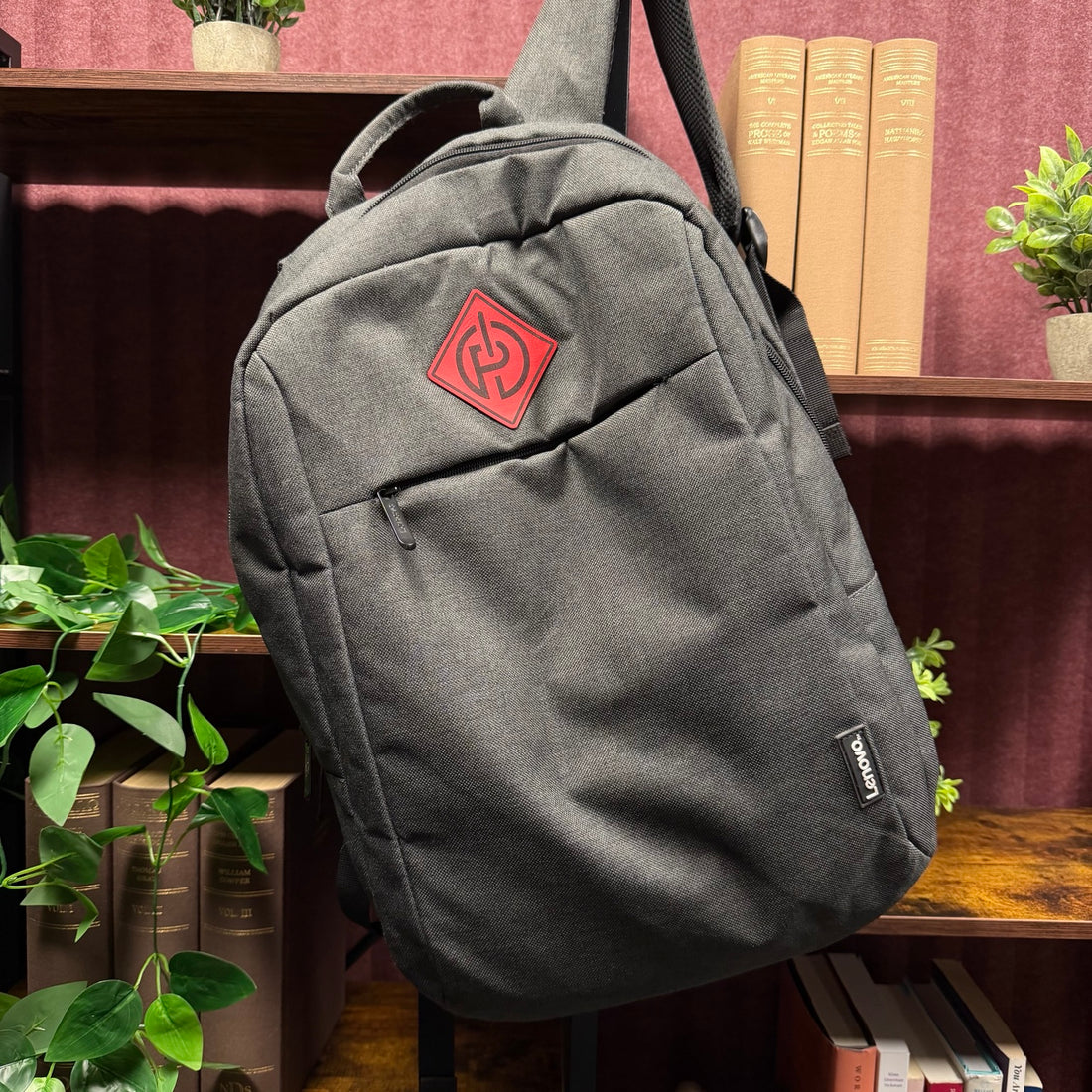 Custom red logo patch on a black backpack for a local IT company