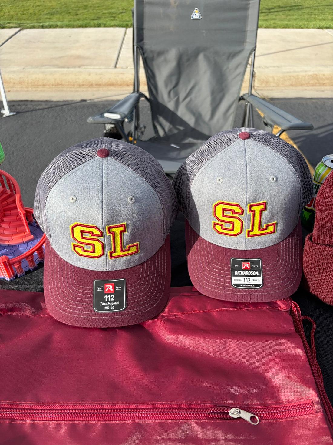 Gray and burgundy embroidered SL hats for the school fall festival
